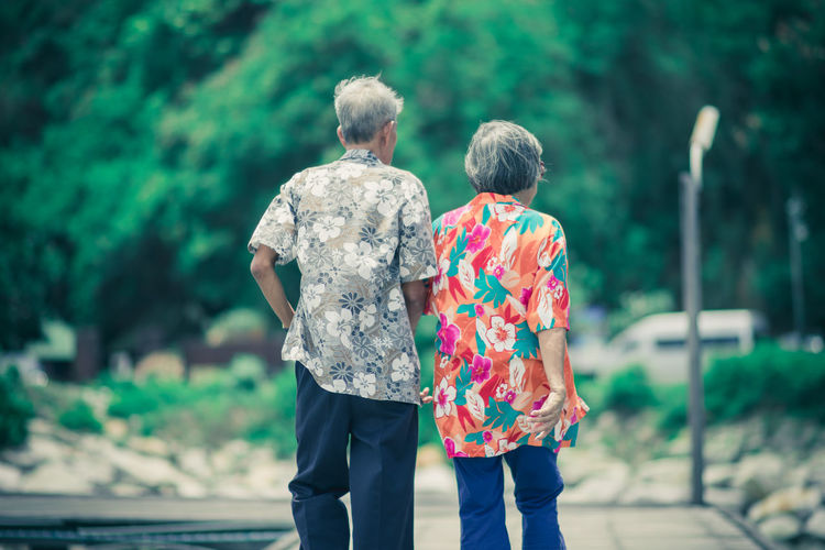 Rear view of senior couple walking on footpath