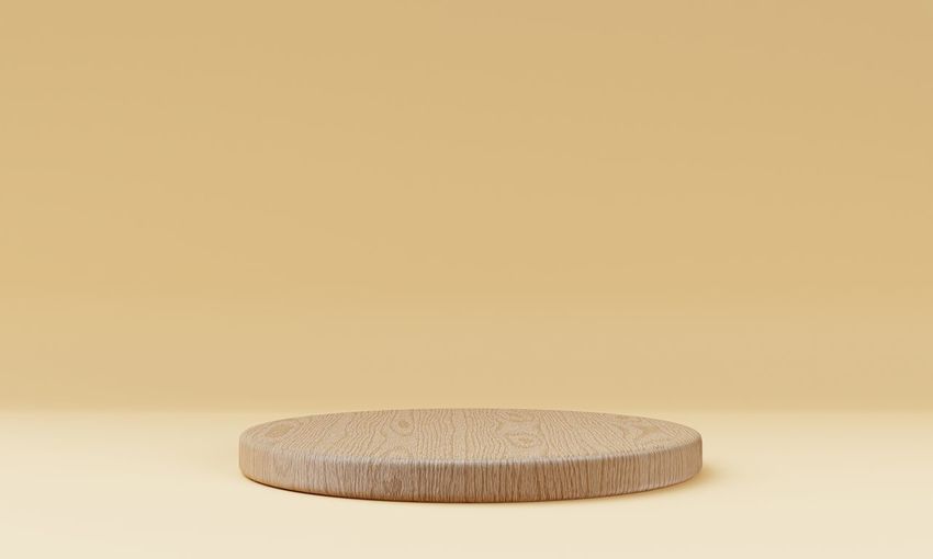 Close-up of wooden table against wall