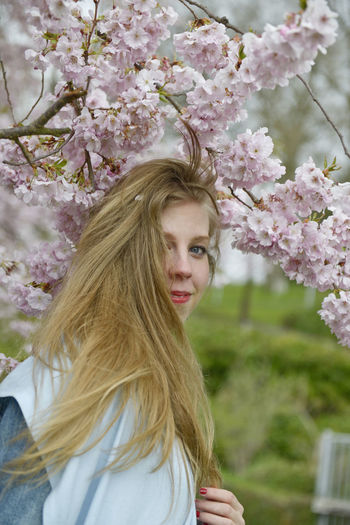 Portrait of beautiful woman with flowers on tree