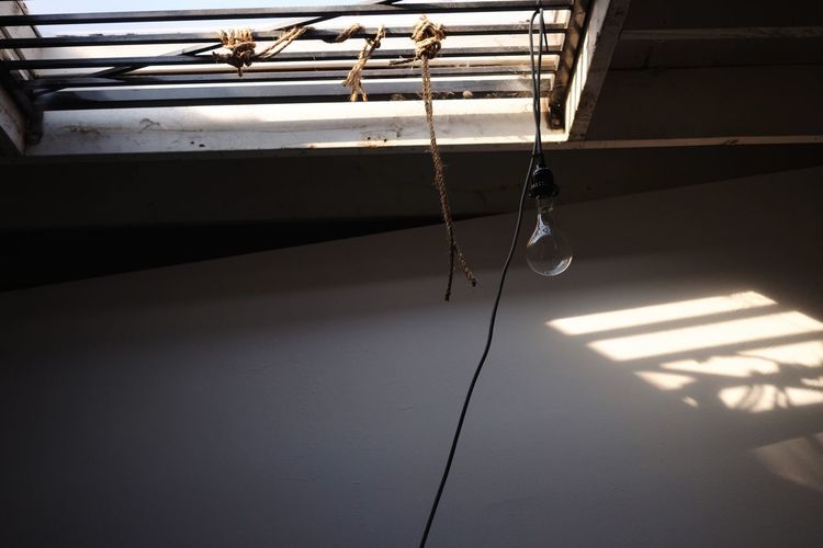 Lighting bulb hanging from ceiling window