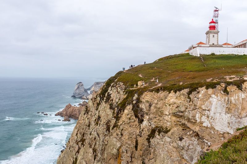 Lighthouse by sea against sky at cabo da roca