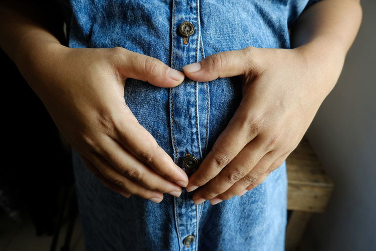 Midsection of pregnant woman touching her stomach