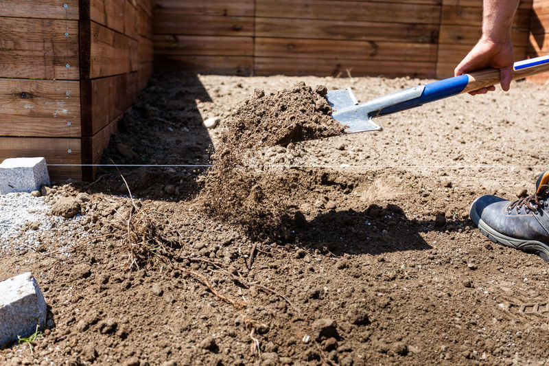 Low section of person on sand at construction site