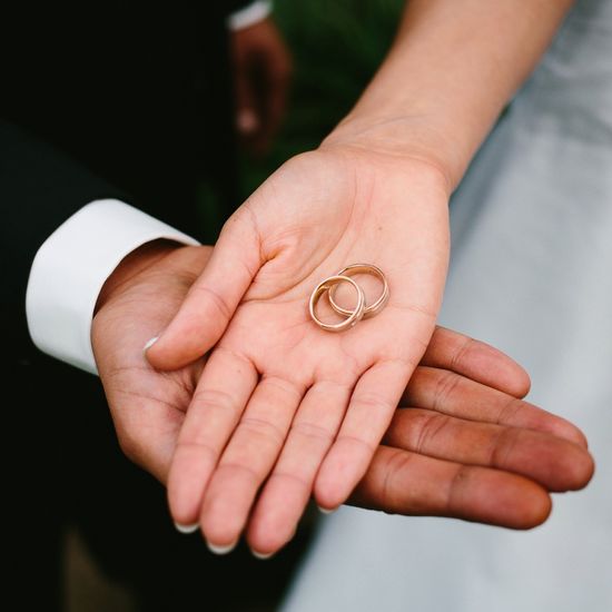 Close-up of hands holding wedding rings