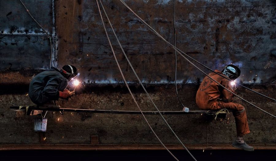 Full length of welders working