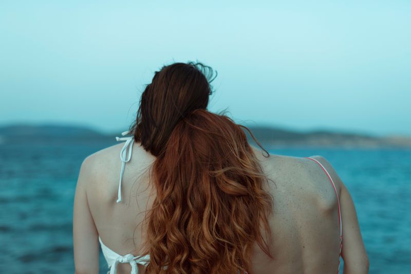 Rear view of lesbian couple at beach
