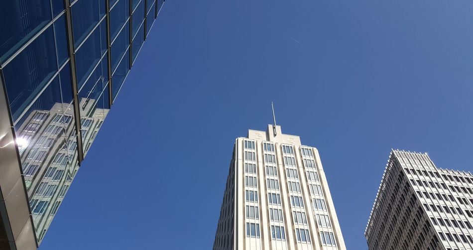 Low angle view of skyscrapers against clear blue sky