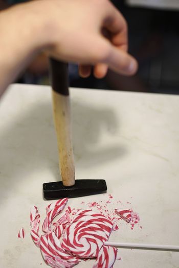 Close-up of hand crushing lollipop