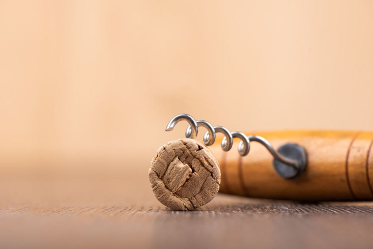 Wine cork and corkscrew on a wooden surface.