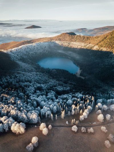 Winter wonderland. frosty forest,blue volcano lake. sunrise over the mountains. aerial view