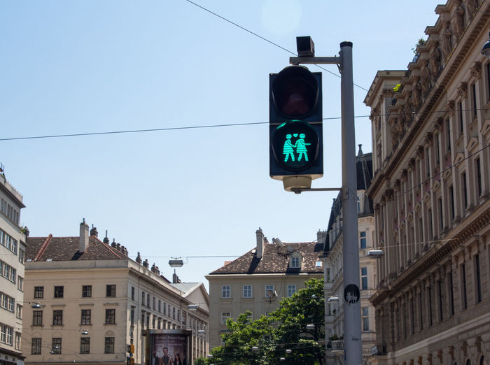 Low angle view of road signal against buildings in city