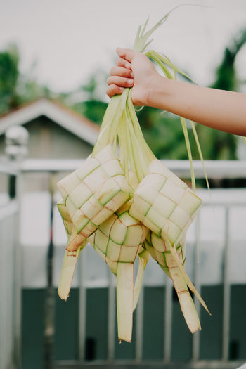 Cropped hand of a woman holding ketupat is a regional speciality during the festive season
