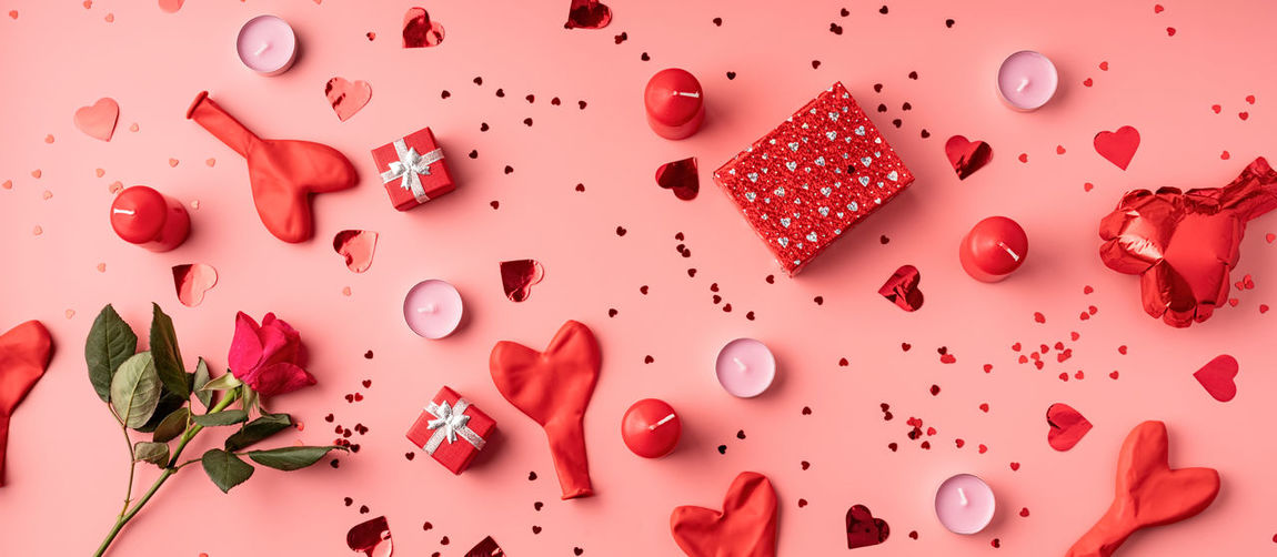 Valentines day. red decorations balloons, candles, confetti and gifts top view flat lay on