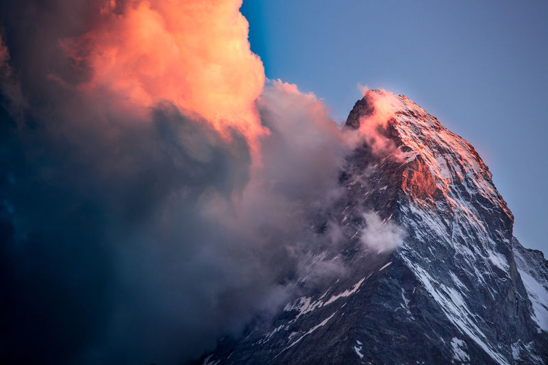 Scenic view of matterhorn by clouds during sunset in winter