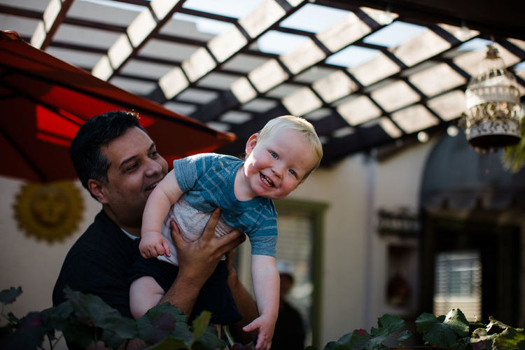 Uncle holding nephew in front yard in san diego