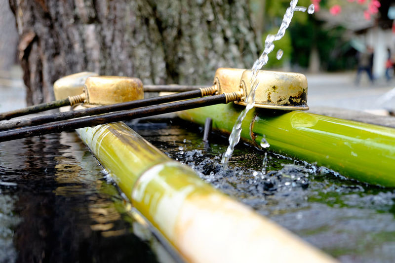 Close-up of bamboo dipper water fountain with ladles