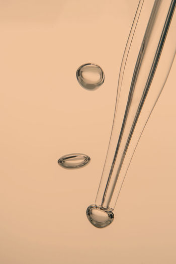 Pipette with cosmetic product in water with bubbles.