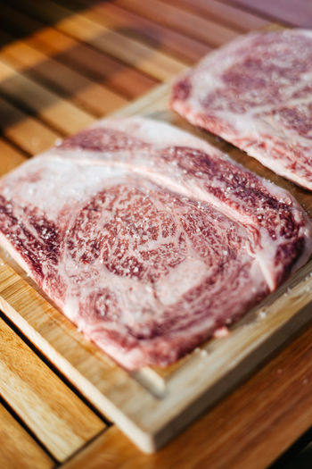 High angle view of two raw wagyu kobe steaks on a cutting board