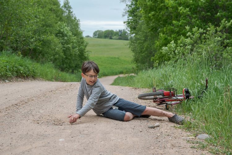 Full length of kid lying down on a country road