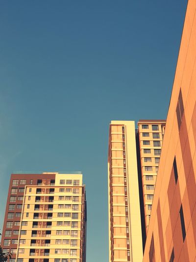 Low angle view of buildings against clear blue sky