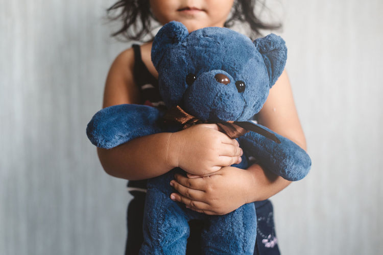 Midsection of girl holding toy indoors