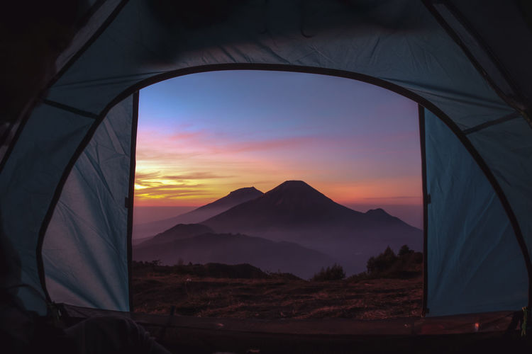 Scenic view of tent on mountain against sky during sunset