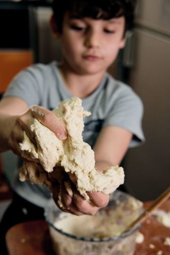 Child preparing pizza dough to make at home