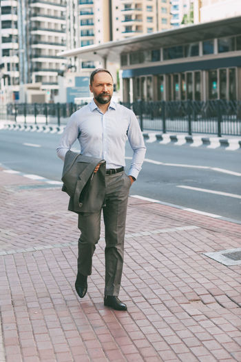 Businessman walking on footpath in city