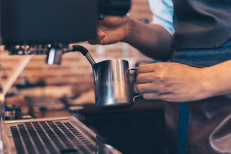Midsection of man preparing coffee in cafe