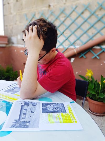 Midsection of man reading book on table