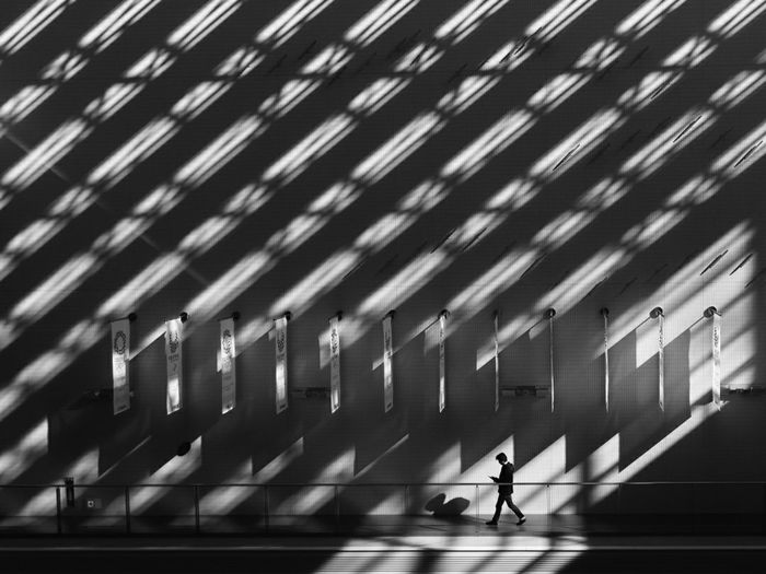 Silhouette man walking on building in city