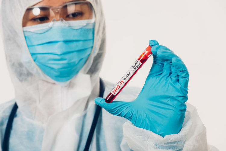 Doctor holding test tube against white background