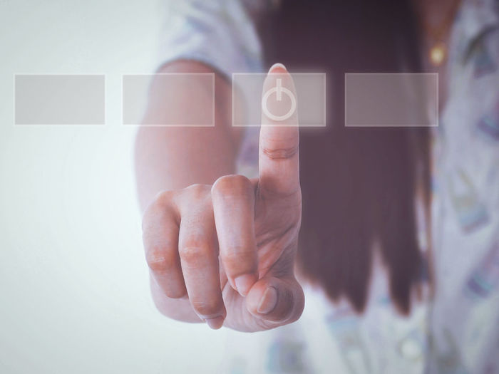 Digital composite image of woman touching button on invisible screen with icon