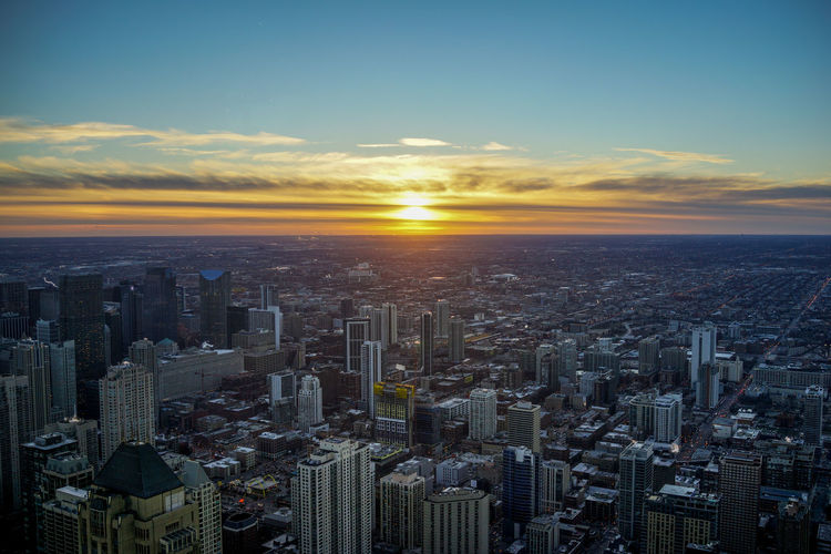 Aerial view of buildings against sky during sunset